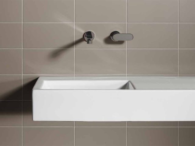 beige rectangle tiled wall and sink