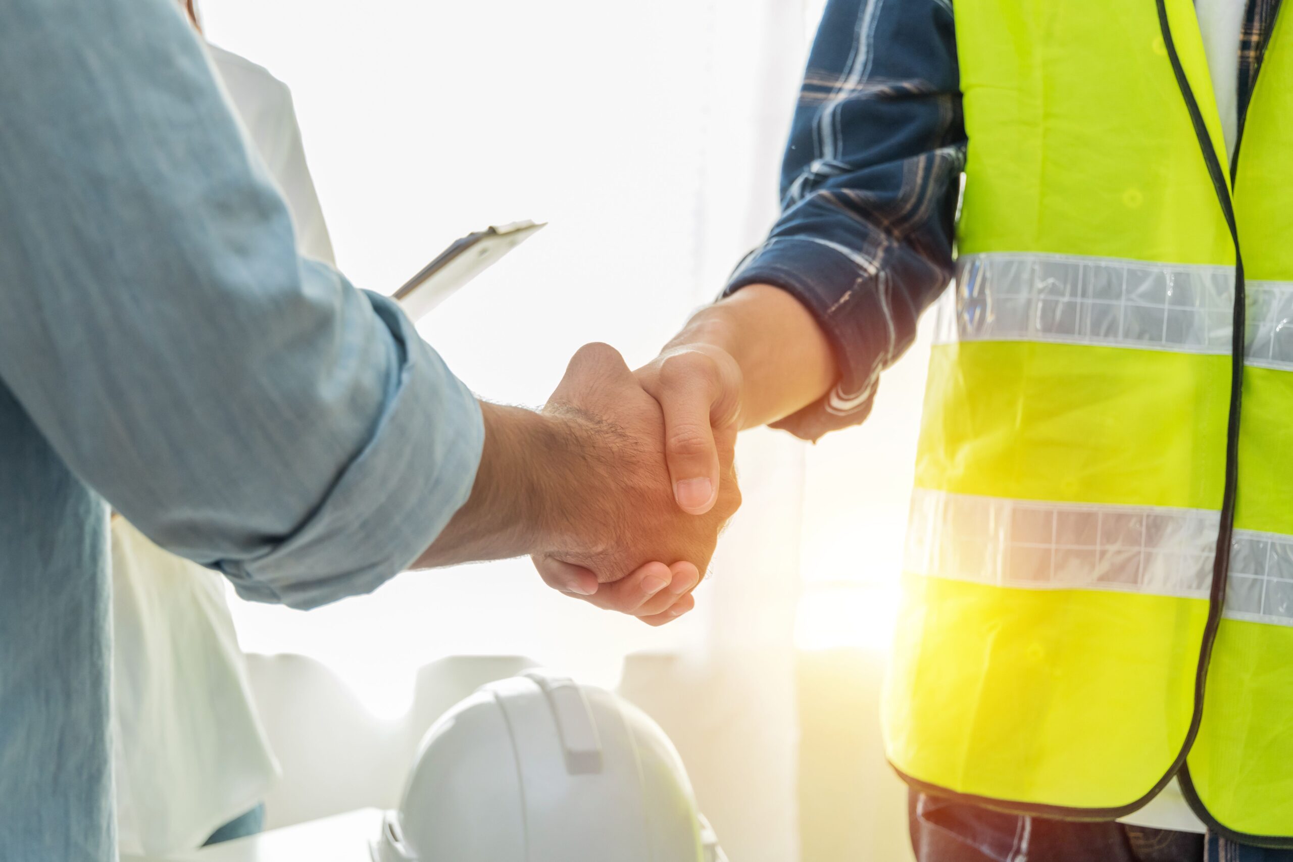 Contractor. construction worker team hands shaking after plan project contract on workplace desk in meeting room office at construction site, contractor, engineering, partnership, construction concept