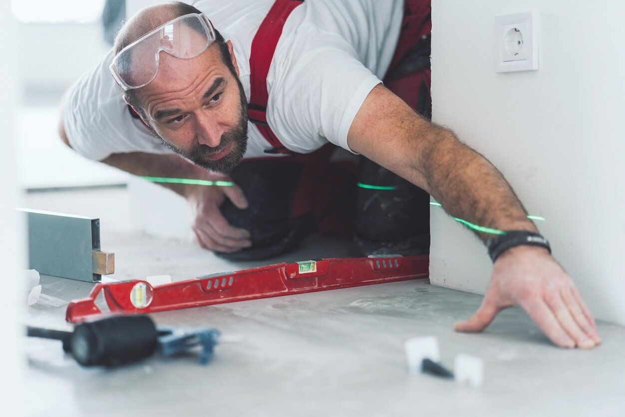 Builder measuring tiled floor